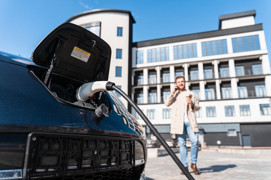 stylish-man-waiting-while-his-car-is-charging-station